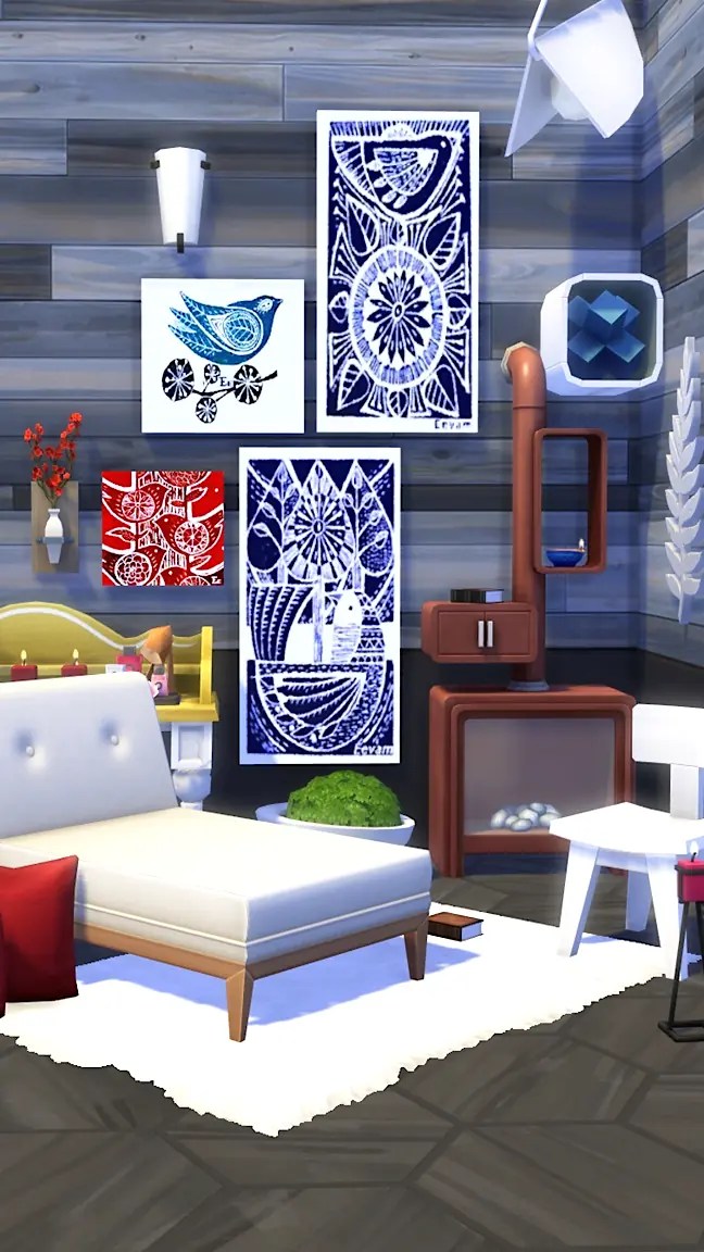 A modern living space, The Sims 4, featuring a white sofa with decorative pillows, a green plant, and a white rug on a dark wooden floor. The walls are decorated with various artworks, including blue and red prints. A small table and a wooden cabinet are visible in the background along with decorative items.