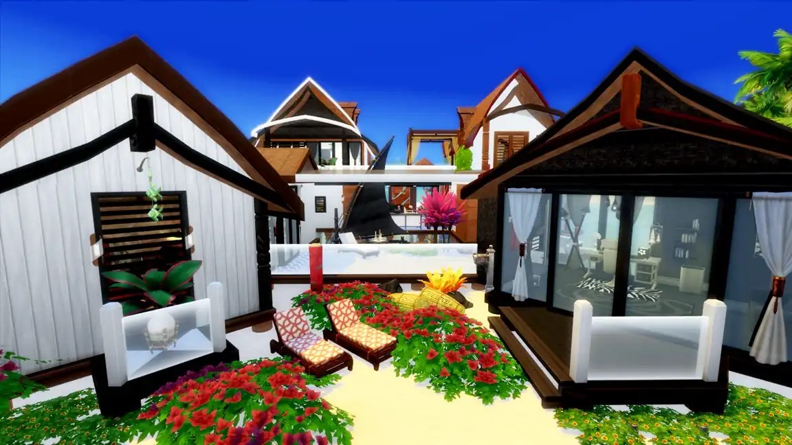 A vibrant outdoor scene featuring several modern, uniquely designed houses surrounded by lush greenery and colourful flowers. Lounge chairs with patterned cushions are positioned in the garden area, under a clear blue sky.